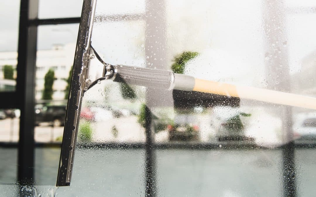 close-up view of cleaning and wiping window with squeegee