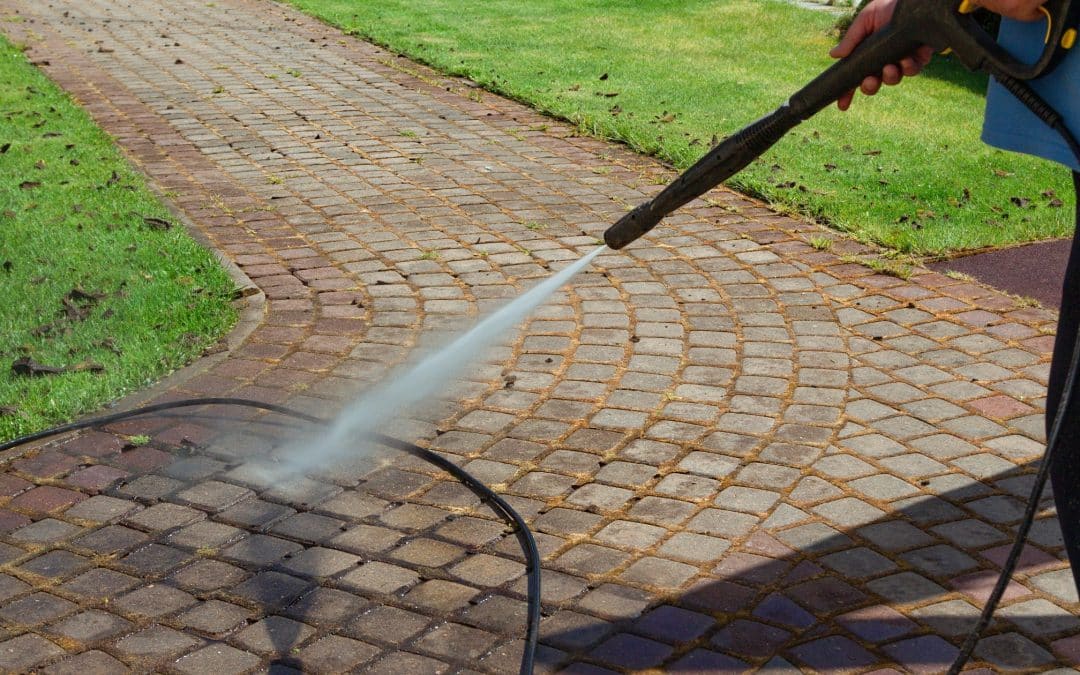 Worker cleaning a walkway with a pressure washer