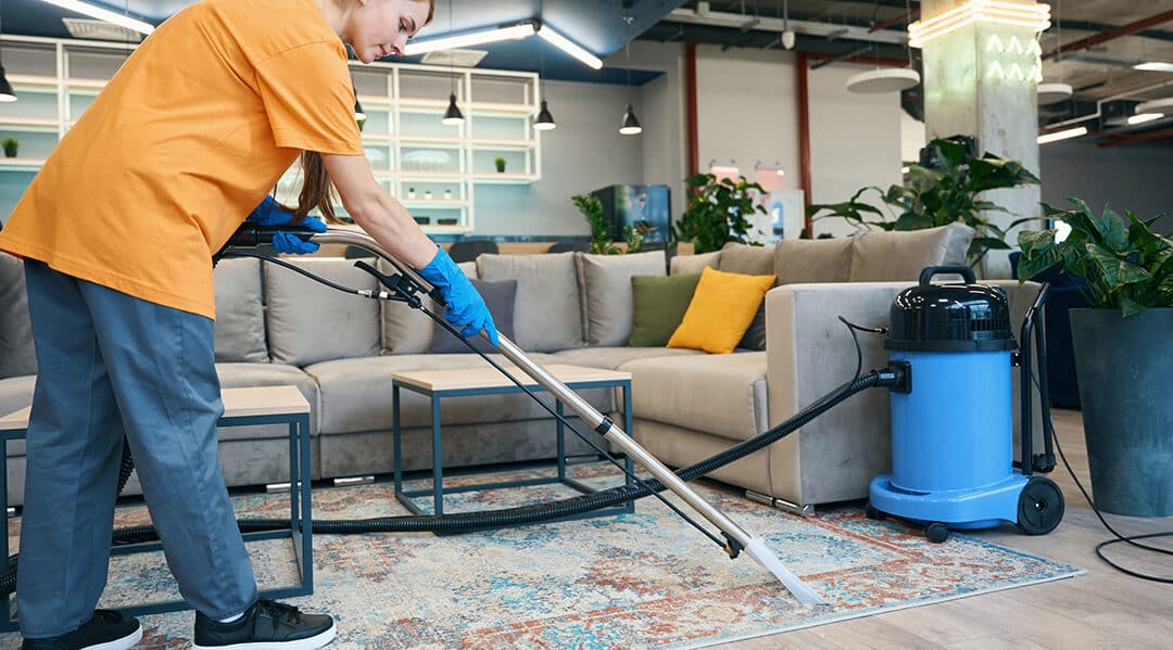 Janitor cleaning carpets in an office