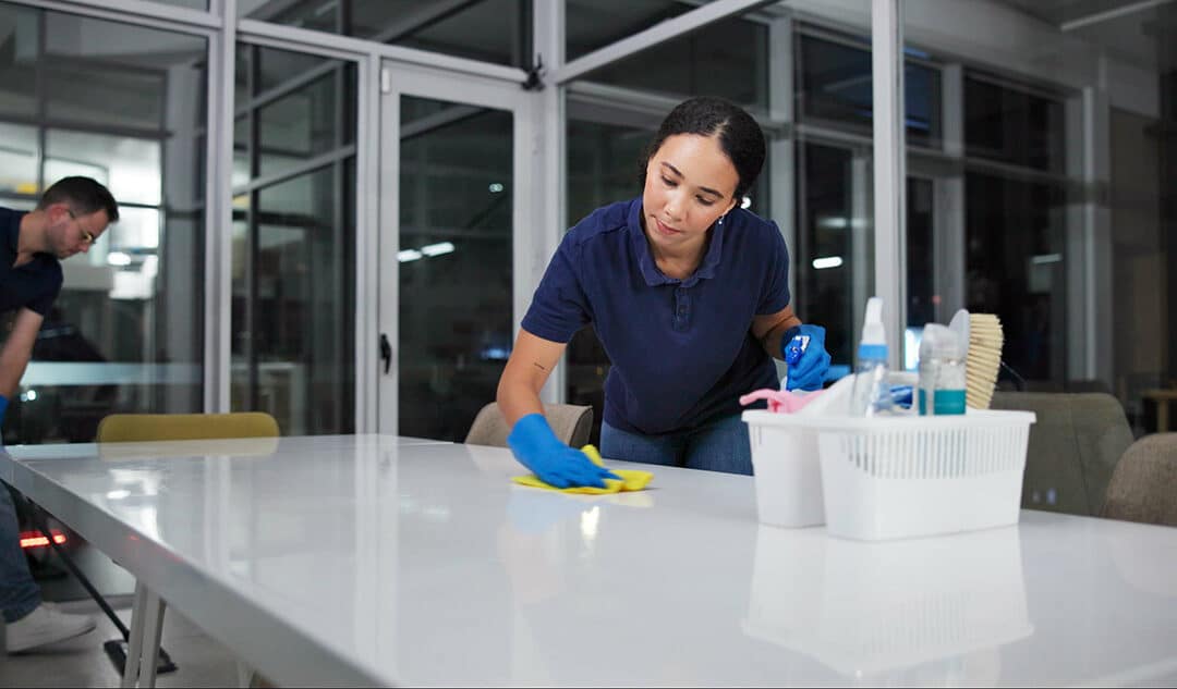 Two janitors sanitizing and mopping an office