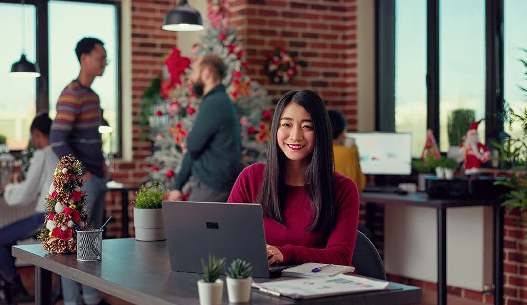 Woman sitting at a desk in an office decorated for the holidays