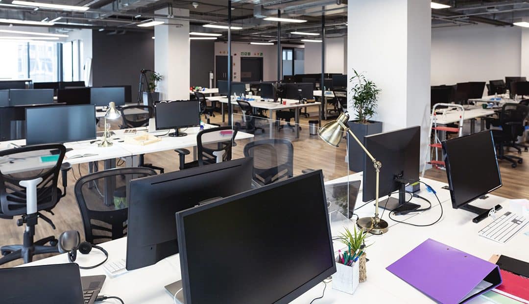 Modern office interior with tables, office chairs, monitors, keyboards and binders